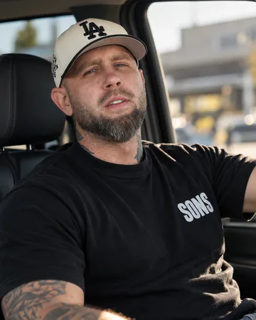 Trevor Stuckless, leader of Sons of Scripture, in a black Sons T-shirt and a ball cap.